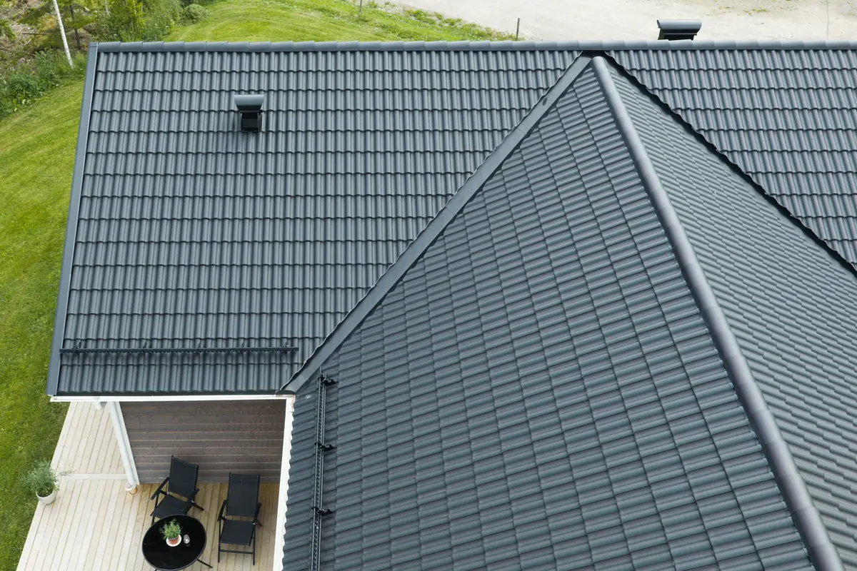 Drönarbild av ett nylagt tak med svarta takpannor på en villa